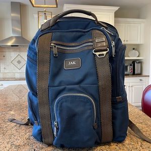 Tumi blue and black backpack. All zips & interior excellent. Two small spots.